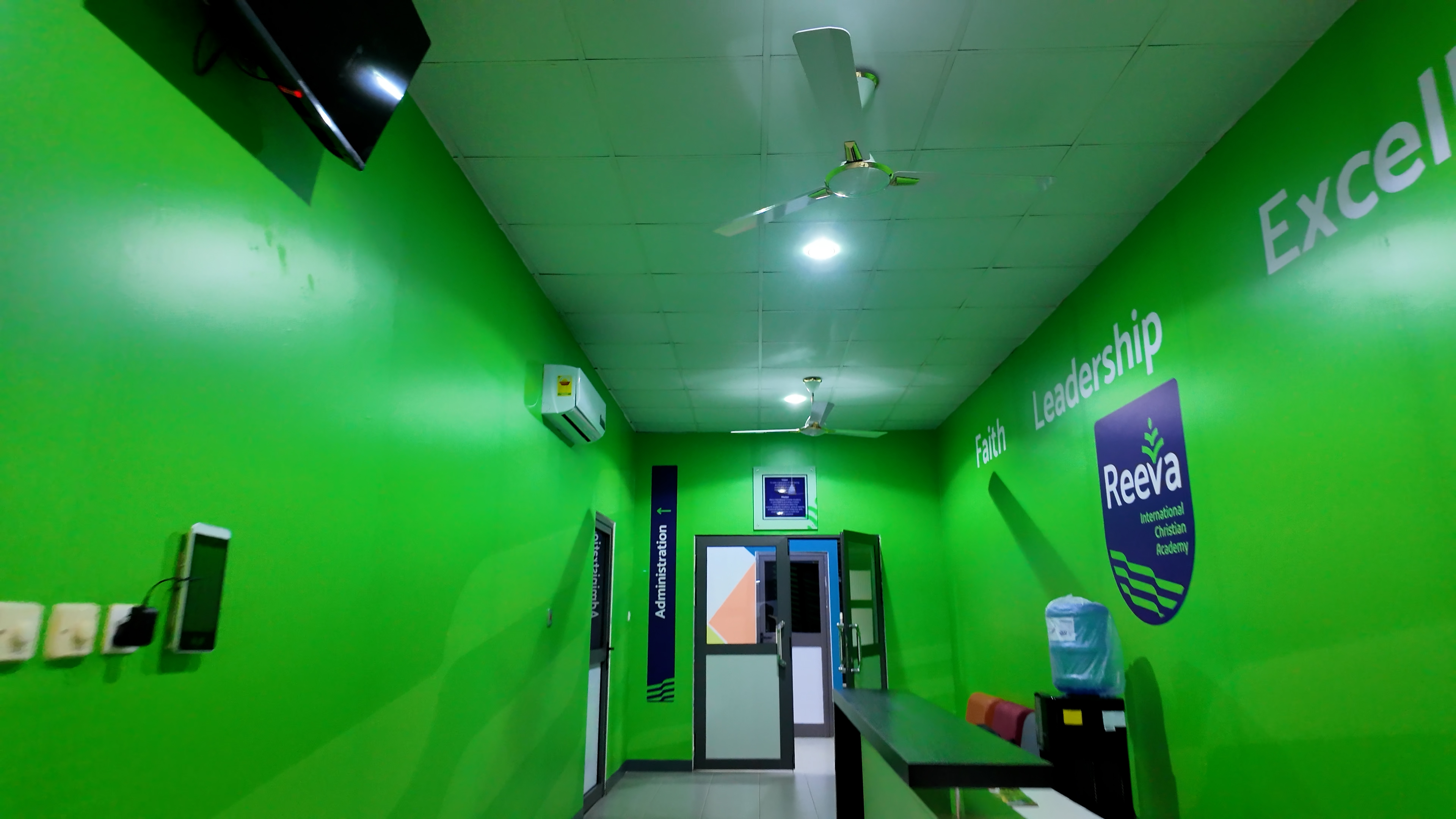 Reeva International Christian Academy administration corridor with Faith, Leadership, Excellence branding